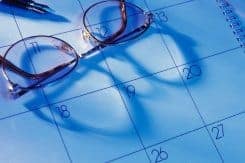Desk calendar with pen and reading glasses